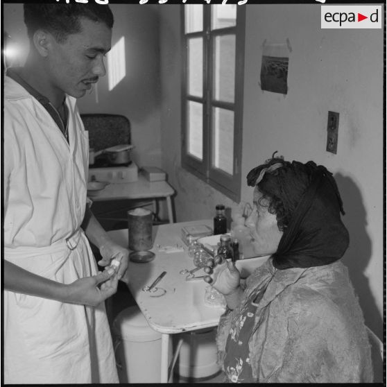 L'infirmier civil Mouloud Dechir dispense des soins à une femme.