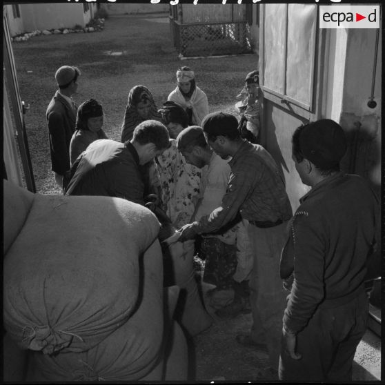 Des sacs d'orge sont distribués aux femmes.