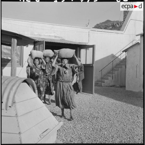 Des sacs d'orge sont distribués aux femmes.