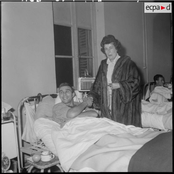 La chanteuse Yvette Giraud salue un blessé.