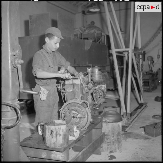 Centre de formation de la jeunesse algérienne : à l'intérieur de l'atelier de mécanique, portrait d'un élève âgé de 18 ans, de El Affroun, en plein travail.