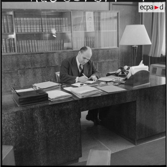 Portrait du secrétaire général de l'Administration en Algérie, André Jacomet, à son bureau.