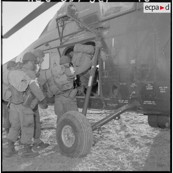 Les soldats montent à bord d'un hélicoptère de transport Sikorsky H-34.