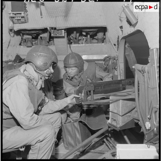 Des soldats manipulent un canon de 20 mm monté en sabord (MG-151/20) sur Sikorsky "Barlu canon".