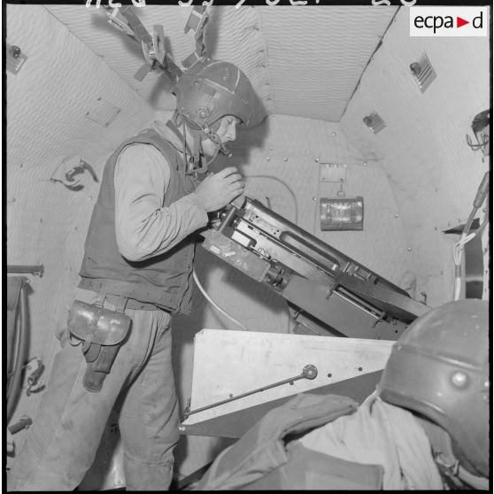 Un soldat manipule un canon de 20 mm monté en sabord (MG-151/20) sur Sikorsky "Barlu canon".