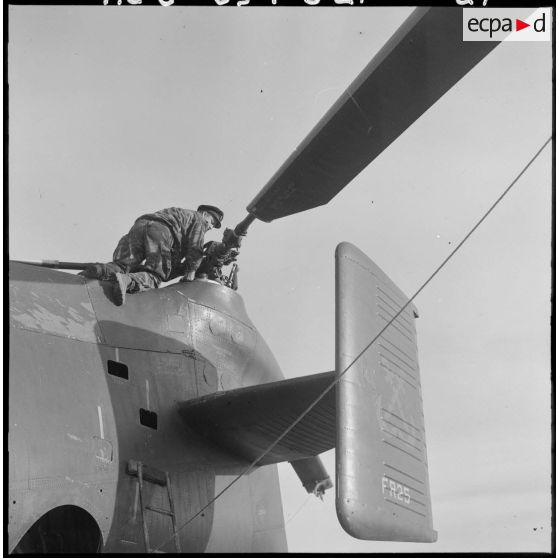 Un soldat vérifie l'hélice d'un hélicoptère de transport Piasecki H-21.