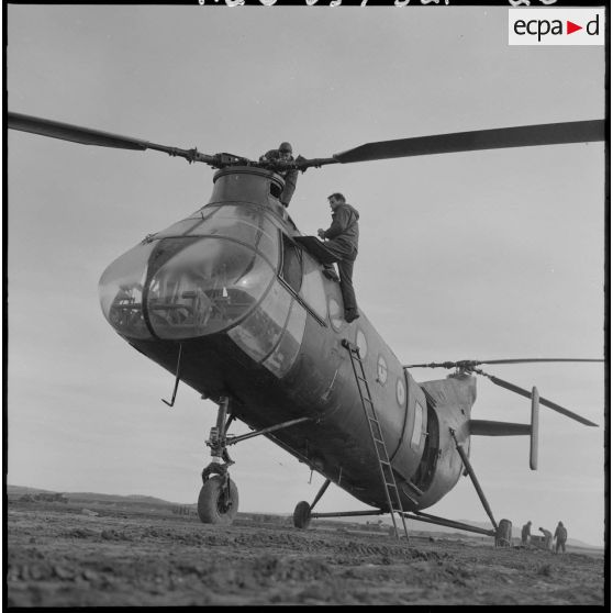 Des soldats vérifient l'hélice d'un hélicoptère de transport Piasecki H-21.