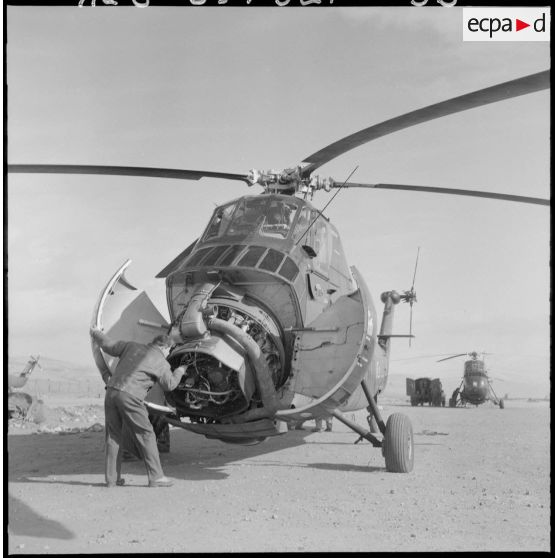 Un soldat vérifie le moteur d'un hélicoptère de transport Sikorsky.