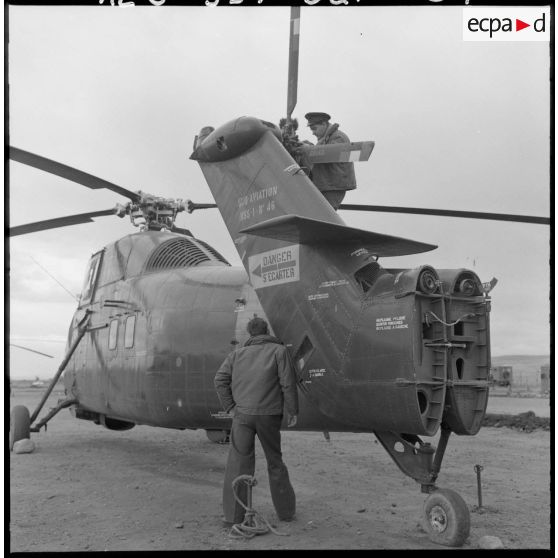 Un soldat vérifie l'hélice d'un hélicoptère de transport Sikorsky.