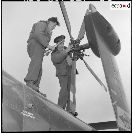 Des soldats vérifient l'hélice d'un hélicoptère de transport Sikorsky.