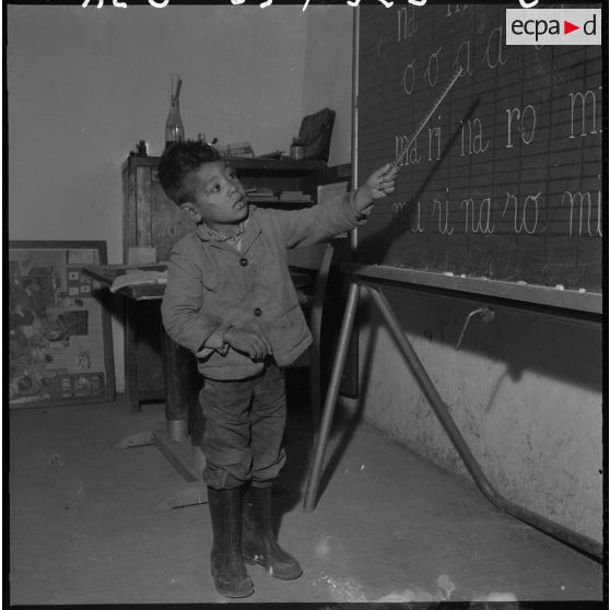 Poste du douar de Kahelia. Un enfant du douar passe au tableau noir.