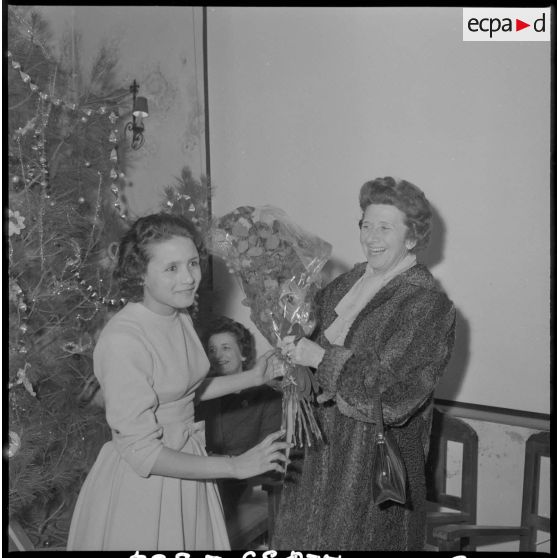 Alger. Cercle de la liberté. Une femme offre des fleurs à madame Massu.