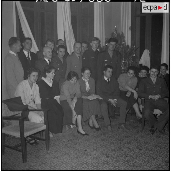 Veillée de Noël au foyer Panorama. Tous les jeunes gens de la soirée réunis autour de l'aumônier Lienhardt.