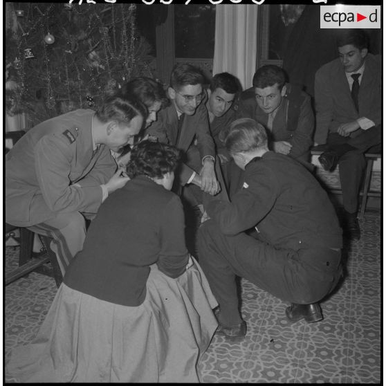 Veillée de Noël au foyer Panorama. Autre groupe jouant aux charades en présence de l'aumônier Lienhardt.