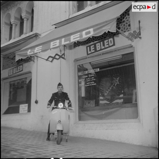 Un aviateur devant le siège du journal Le Bled à Alger avec son scooter. [Description en cours]