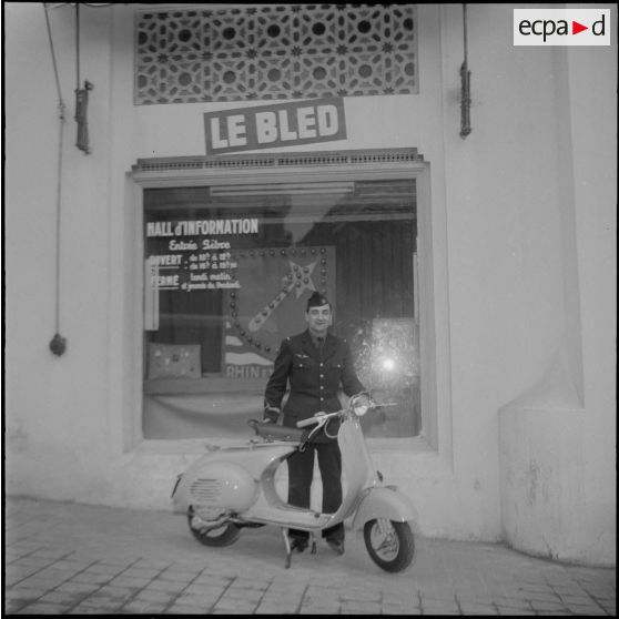 Un aviateur devant le siège du journal Le Bled à Alger avec son scooter. [Description en cours]