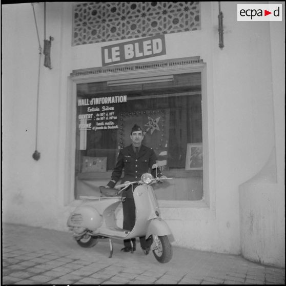 Un aviateur devant le siège du journal Le Bled à Alger avec son scooter. [Description en cours]