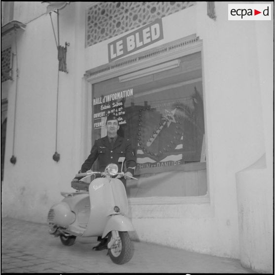 Un aviateur devant le siège du journal Le Bled à Alger avec son scooter. [Description en cours]