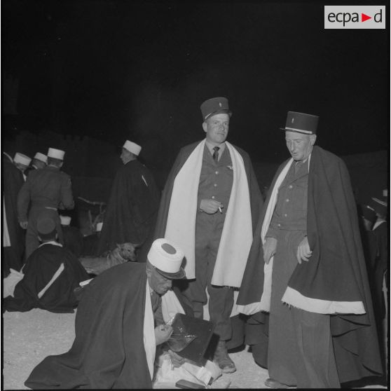 Trois légionnaires contemplant les cadeaux qu'ils viennent de recevoir.