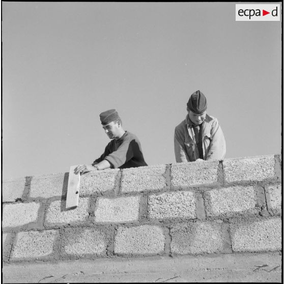 Mekhadmas. Deux soldats édifiant un mur.