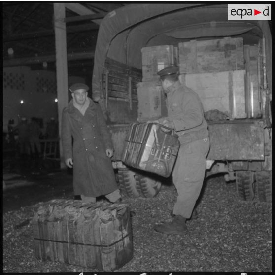 Le ravitaillement de la 13e demi-brigade de Légion Etrangère (D.B.L.E.) est chargé dans les camions pour être embarqué à bord du bateau.