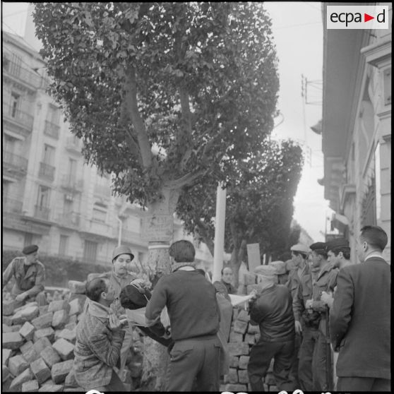 Le transport d'un blessé, membre des unités territoriales dans la matinée du 27 janvier 1960.