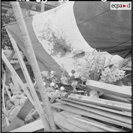Fleurs, drapeau et croix de la valeur militaire sur la barricade "Hernandez" dans la matinée du 27 janvier 1960.