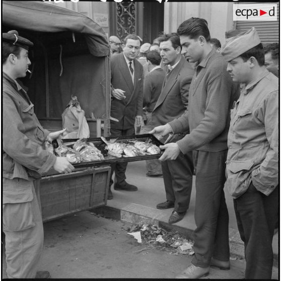 Actions de fraternisation : des Algérois distribuent des poissons aux forces de l'ordre lors de la manifestation du 27 janvier 1960 à Alger.