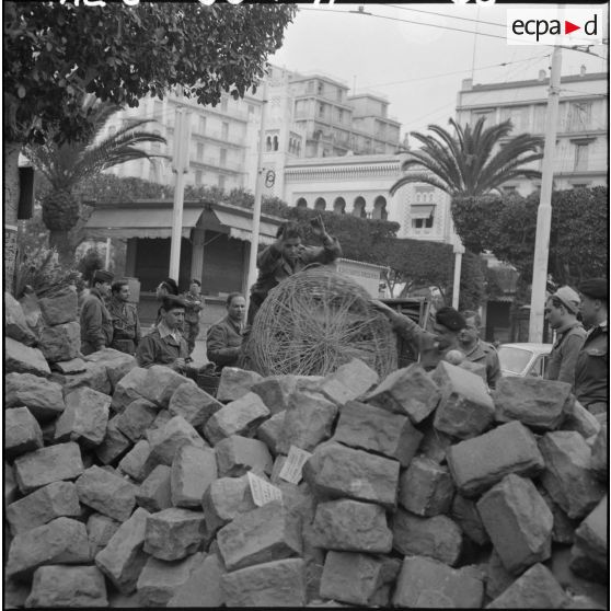 Les pavés de la barricade située dans le secteur de la Grande Poste, rue Charles Péguy, ont été renforcés par l'ajout de rouleaux de barbelés.