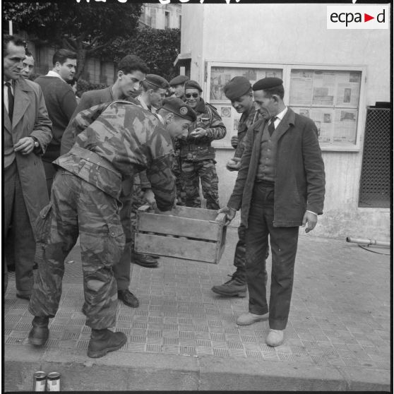 Actions de fraternisation : des Algérois distribuent des oranges et du poisson aux forces de l'ordre lors de la manifestation du 27 janvier 1960 à Alger.