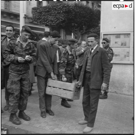 Actions de fraternisation : des Algérois distribuent des oranges et du poisson aux forces de l'ordre lors de la manifestation du 27 janvier 1960 à Alger.
