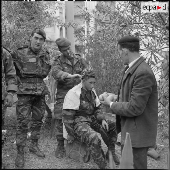 Vie courante en marge des manifestations du 27 janvier 1960 à Alger : séance de coiffure chez des parachutistes du 1er RCP (régiment de chasseurs parachutistes).
