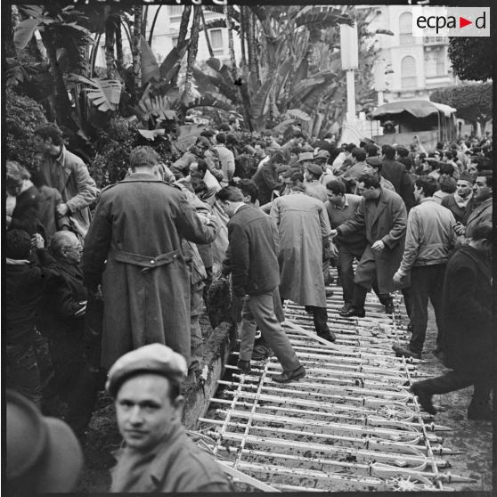 Les grilles tombées, un nouveau passage s'offre à la foule qui se presse aussitôt vers les barricades.