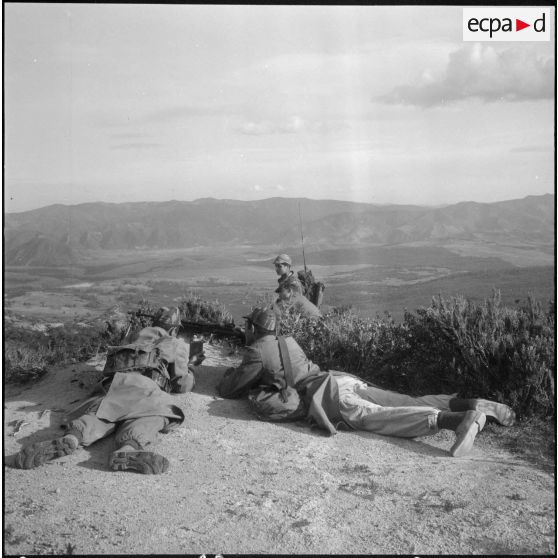 Les commandos Harkis sur les hauteurs assurent  la protection des civils transportants leurs affaires vers le village regroupé.