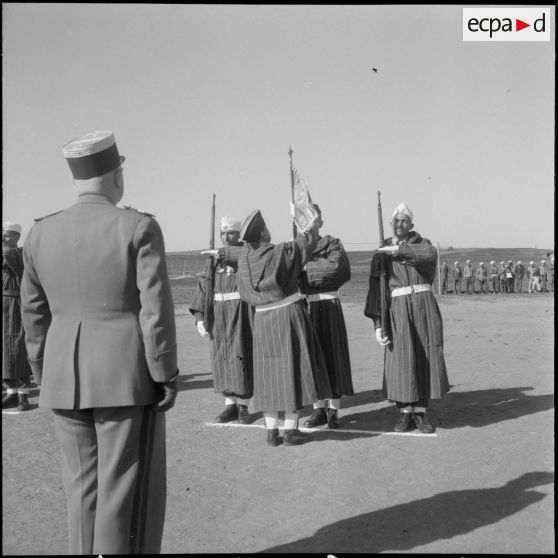 Le commandant inspecteur Prothin, remet le fanion d'un groupe au capitaine Henck qui le place lui-même, au bout d'un fusil.