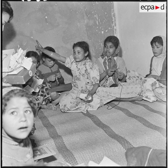 Colomb-Béchar. Une institutrice apprend la lecture à des petites filles.