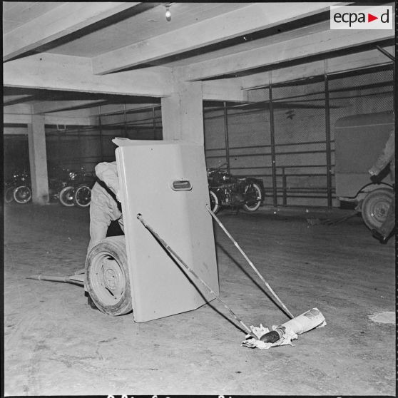 Alger. Les artificiers de la police d'Etat. Utilisation du bouclier protecteur, en métal de 10 mm d'épaisseur. L'artificier opère avec des perches.