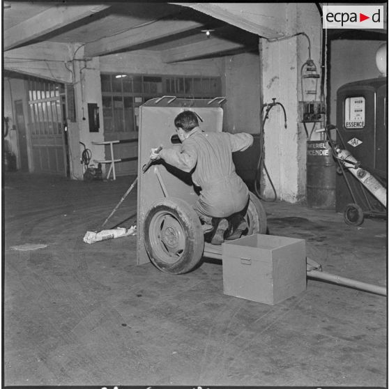 Alger. Les artificiers de la police d'Etat. Utilisation du bouclier protecteur, en métal de 10 mm d'épaisseur. L'artificier opère avec des perches.