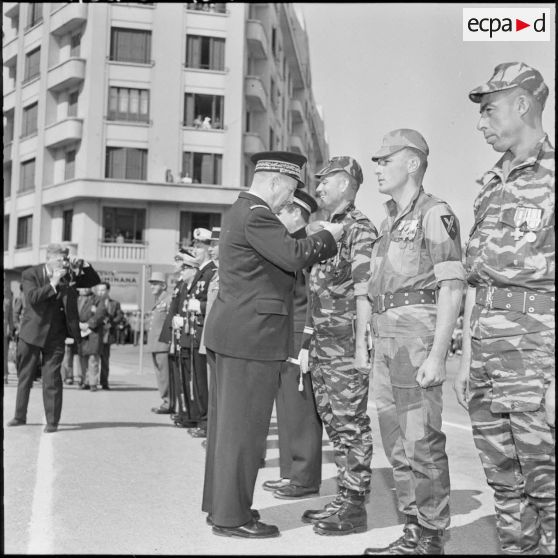 Oran. Adieux du général Challe au Corps d'Armée d'Alger (CAO). Les lieutenants Grillot (commandant le Commando Georges) et Paget (commandant le commando Cobra) ainsi que l'aspirant (ou adjoint du commando Georges ?) Youssef Bel-Brahim reçoivent la valeur militaire avec étoile de Vermeil.
