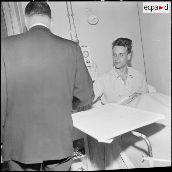 Alger. Hôpital militaire Maillot. Paul Delouvrier visite un malade.