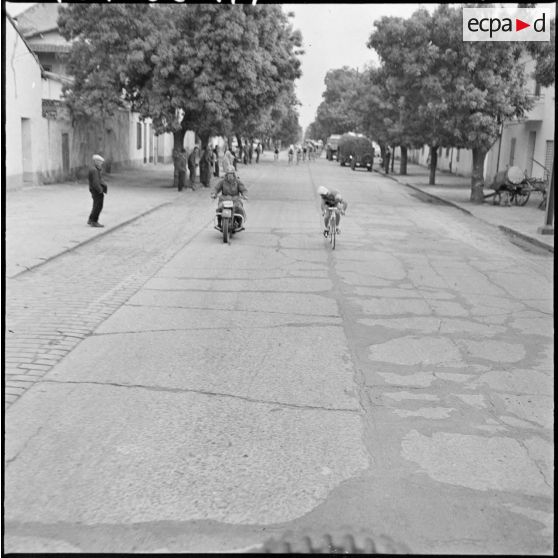 Prix cycliste 1960 du département de Bône. Passage d'un coureur dans la localité de Duzerville.