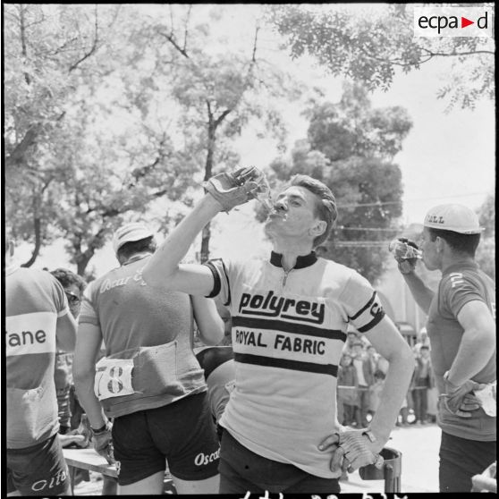 Prix cycliste 1960 du département de Bône. Le coureur Aubry se rafraîchit à son arrivée à Tebessa.