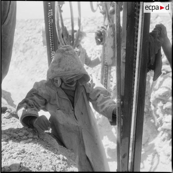 Gazoduc d'Arzew. Portrait d'un ouvrier en tenue de protection réalisant une manoeuvre.