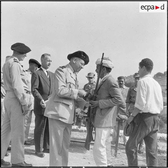 Grande Kabylie. Pierre Messmer et une autorité militaire remettent à l'autodéfense du village de Bounan quelques armes.