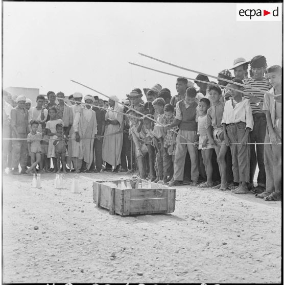 Colomb-Béchar. Festivités du 14 Juillet 1960 dans la zone ouest sud (ZOS). Les jeux dirigés par la gendarmerie attirent les enfants qui se pressent autour des stands improvisés.