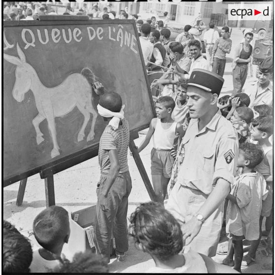 Colomb-Béchar. Festivités du 14 Juillet 1960 dans la zone ouest sud (ZOS). Les jeux dirigés par la gendarmerie attirent les enfants qui se pressent autour des stands improvisés.