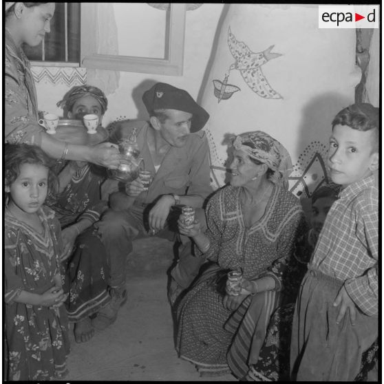Kabylie. 7e bataillon de chasseurs alpins (BCA). Des soldats prennent un thé avec des villageoises dans une maison.