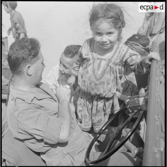 Kabylie. 7e bataillon de chasseurs alpins (BCA). Des enfants à la rencontre de soldats en jeep.