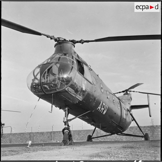 Aïn Arnat. Prise d'armes à la base de l'ALAT (aviation légère de l'armée de terre). Un hélicoptère Piasecki sur le terrain d'aviation.