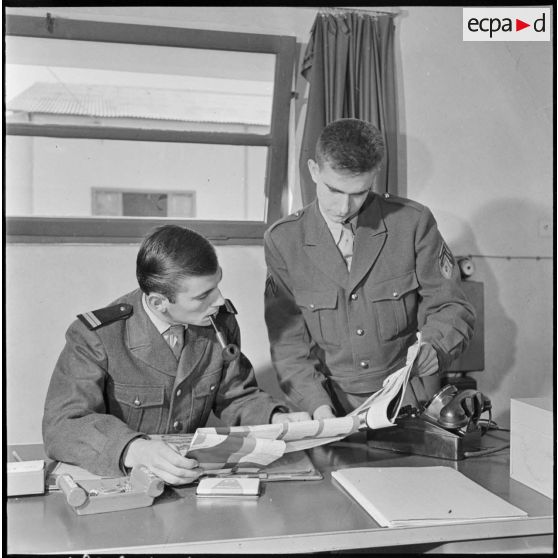 Algérie. Des militaires du 3e bureau PH centre d'instruction (CIS) regardant des affiches.